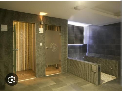 a bathroom with a shower with tiled walls at Aparthotel Vucko Jahorina NEW 451 in Jahorina
