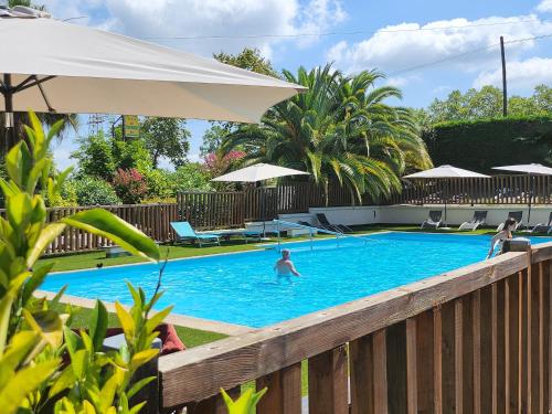 - une piscine avec des personnes à l'eau dans l'établissement CITY NATURE Lescar Pau, à Lescar