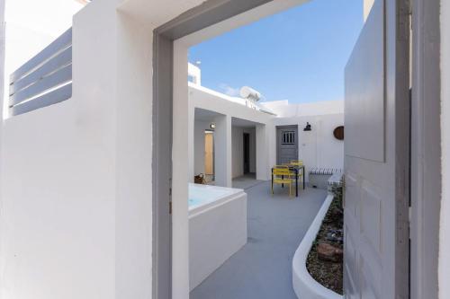 uma casa branca com casa de banho com banheira em Villa Tholos & Prive Jacuzzi em Kamari