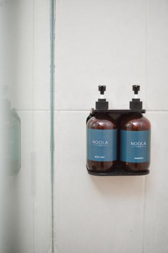 two bottles of alcohol are hanging on a wall at Noola Inn Hotel Bogor in Kamparganya