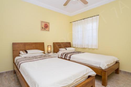 two twin beds in a room with a window at Carvoeiro Apartment 7A in Carvoeiro