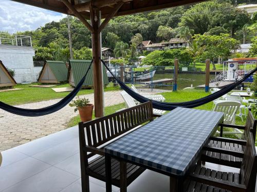 una mesa y sillas con una hamaca y un parque infantil en Floripa Glamping en Florianópolis