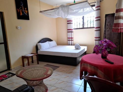 een kleine kamer met een bed en een tafel bij ZARADISE SUITES HOTEL, MOMBASA KENYA in Mombasa
