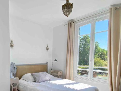 a bedroom with a bed and a large window at Deauville. Grande villa, plage. in Tourgeville