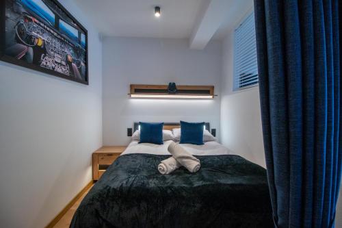 a bedroom with a bed with blue pillows at Apartament AVIATOR - lokalizacja w centrum, wysoki standard, balkon, prywatny parking in Nowy Targ