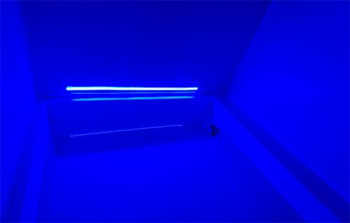 a dark room with a shelf with blue lighting at B&B AntiQua & Qook in Tongeren