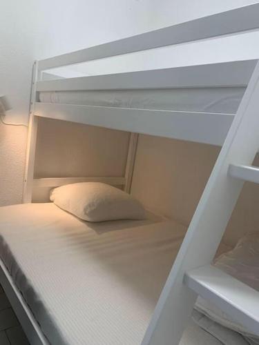 - un lit superposé avec un oreiller sur la couchette inférieure dans l'établissement Sur port de Carnon / Palavas charmant petit studio, à Mauguio
