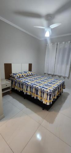 a bedroom with a bed in the middle of a room at Apto Novo no Canto do Forte PG in Praia Grande