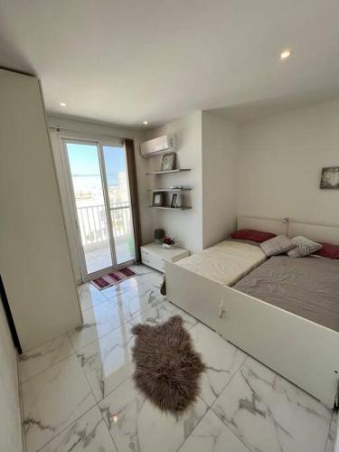 ein Schlafzimmer mit einem großen Bett und einem großen Fenster in der Unterkunft 2 Bedroom Apartment in Msida, Malta in Msida