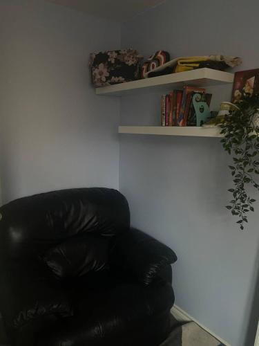 a black leather chair in a room with shelves at Packwood Suite in Welton