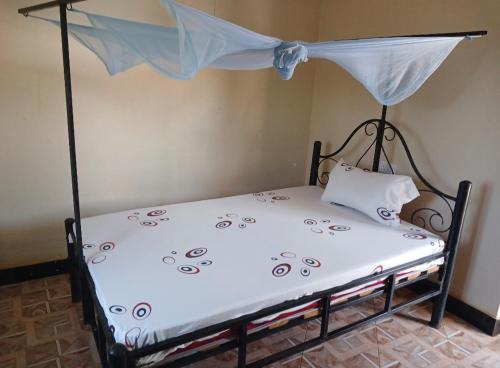 Una cama en una habitación con una cortina. en Mombo Maasai Culture Homestay, 