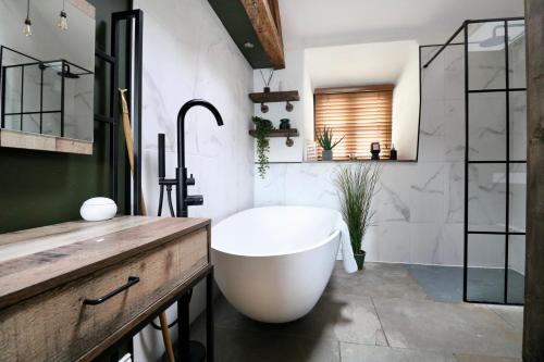 a bathroom with a large tub and a sink at A countryside retreat in Chipping Norton