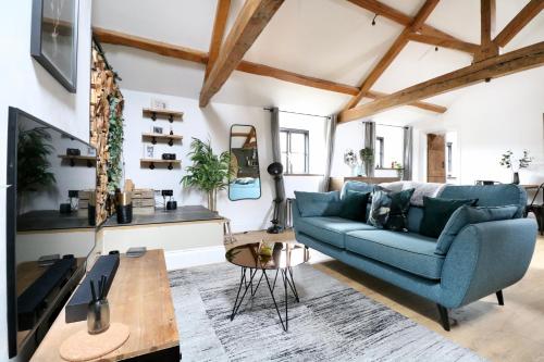 a living room with a blue couch and a table at A countryside retreat in Chipping Norton