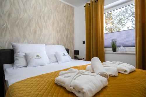 ein Schlafzimmer mit Handtüchern auf einem Bett mit Fenster in der Unterkunft Owocowe Wzgórze in Tęgoborze