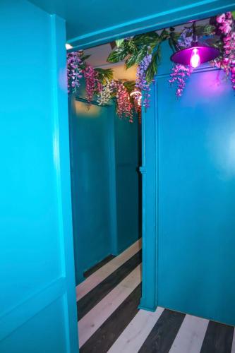 a room with blue walls and a blue door with flowers at The Ultimate Hen Suite with Bar & Makeup Room in Manchester