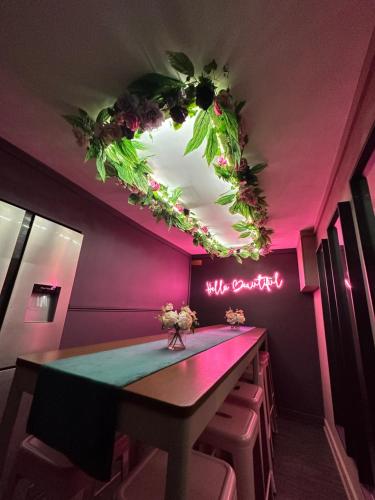 a dining room with a table and pink lighting at The Ultimate Hen Suite with Bar & Makeup Room in Manchester