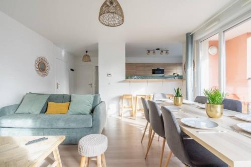 un salon avec un canapé bleu et une table dans l'établissement Le Prague - Parking - Disneyland - Balcon, à Montévrain