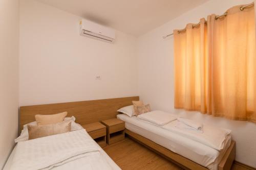 a room with two beds and a window at Holiday Home Malačnica in Supetar