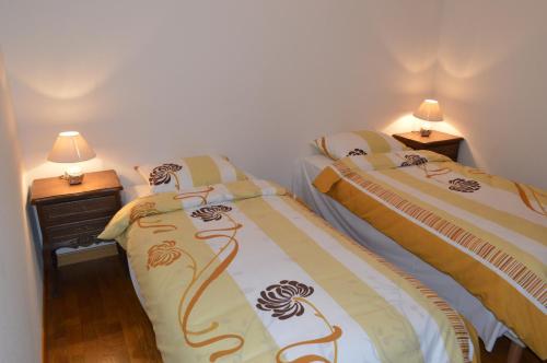 2 camas individuales en una habitación con 2 lámparas en Appartement Timgad, en Gérardmer