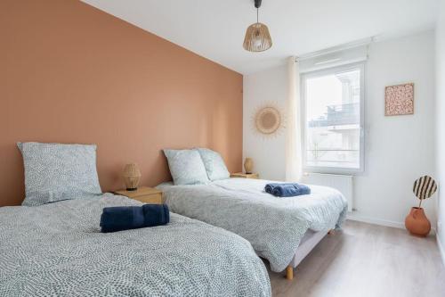 une chambre avec deux lits et une fenêtre dans l'établissement Le Prague - Parking - Disneyland - Balcon, à Montévrain