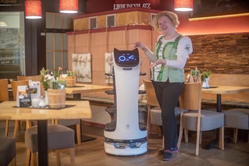 a woman standing next to a robot in a restaurant at Lichtenhainer Wasserfall in Lichtenhain