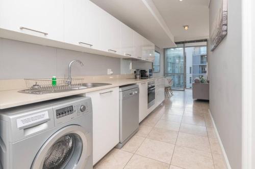 ケープタウンにあるWaterfront Canal Stunning Apartmentのキッチン(洗濯機、シンク付)