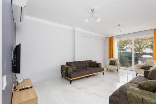 a living room with a couch and a tv at Villa Sasha 1 in Ortaca