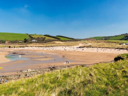 a group of people standing on a beach at 3 bed property in Bantham 87005 in Thurlestone