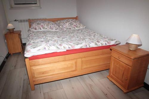 a bed with a wooden bed frame and a night stand at apartament 1000-lecia in Wąbrzeźno