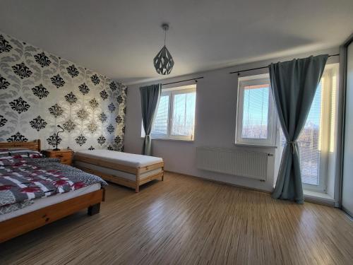 a bedroom with a bed and two windows at Tatry Mountain Paradise in Poprad