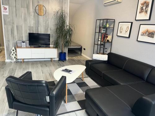 a living room with a couch and chairs and a tv at Apartments RENESANCE in Bojnice