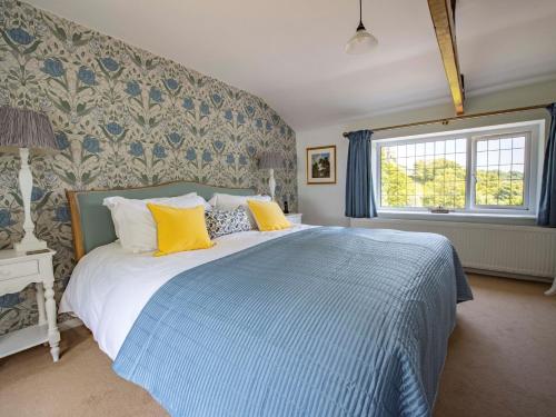 a bedroom with a bed with blue and yellow pillows at 2 Bed in Richmond G0059 in Richmond