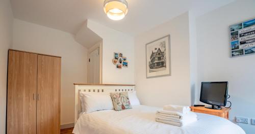 um quarto com uma cama branca e uma televisão. em Exquisite renovation in central location em Hereford