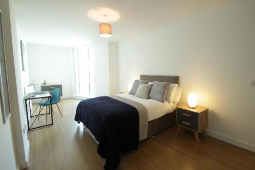 1 dormitorio con 1 cama, 1 mesa y 1 lámpara en Bracknell Centre en Bracknell