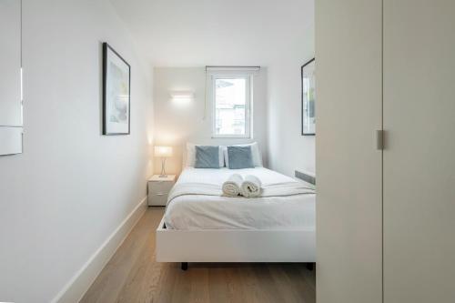 a bedroom with a bed with two towels on it at Riverside 2- Bedroom Apartments in London