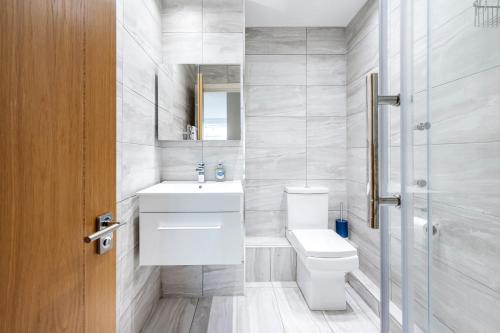 a bathroom with a toilet and a sink and a shower at Riverside 2- Bedroom Apartments in London