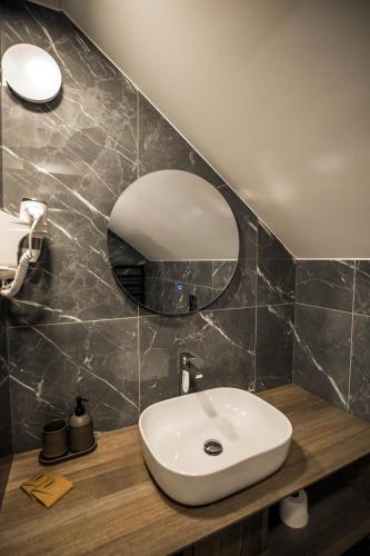 a bathroom with a sink and a mirror at Senamiesčio apartamentai in Anykščiai