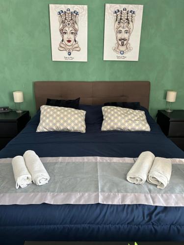 um quarto com uma cama azul com toalhas em Residenza Parco Gioeni em Catânia