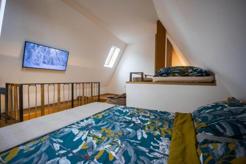 a bedroom with a bed and a tv on the wall at Apartmani RAZVIGORA - DivčiNova in Divčibare