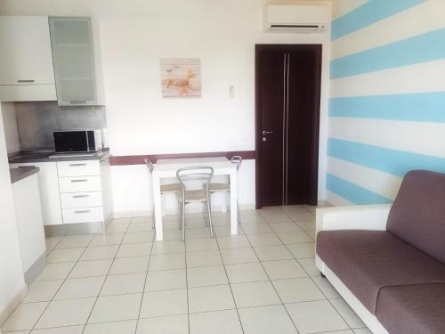 a kitchen with a table and a chair in a room at ALBACHIARA INN Residence Apartments in Ameglia
