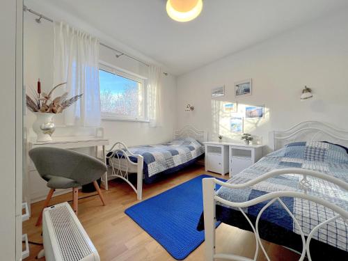 um quarto com 2 camas, uma secretária e uma cadeira em Amphora em Ventspils