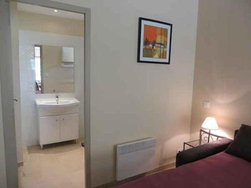 ein Bad mit einem Bett, einem Waschbecken und einem Spiegel in der Unterkunft Domaine de Cassan in Lafare
