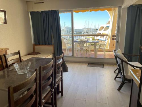 une salle à manger avec une table et un balcon dans l'établissement Studio cabine pour 4 avec piscine et parking à Port Camargue - FR-1-250-207, au Grau-du-Roi