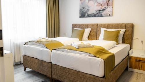 two beds in a hotel room with towels on them at E&B Apartments Waiblingen in Waiblingen