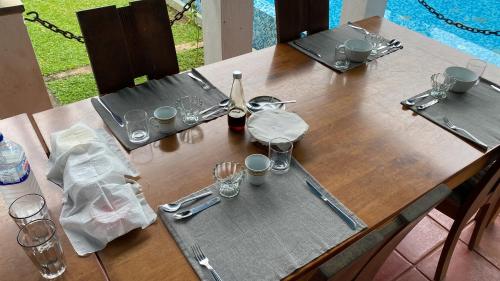 a wooden table with a bottle of wine and glasses at Seth Villa by Magampura Resorts in Tangalle