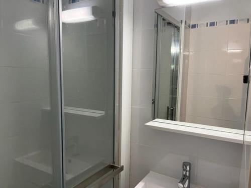 une douche en verre dans une salle de bain avec un lavabo dans l'établissement Studio Cabine à La Roquille, Piscine, Tennis, Parking, Proche Plages et Village Naturiste - FR-1-749-21, au Cap d'Agde