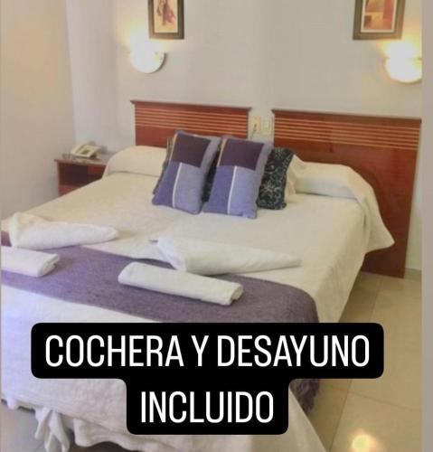 a hotel room with a bed with purple pillows at Hotel Plaza San Juan in San Juan