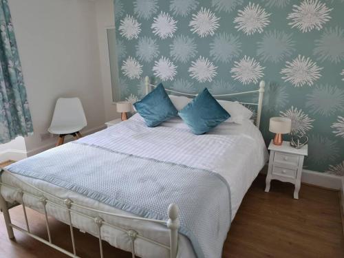 a bedroom with a bed with blue pillows at Cosy home in Stornoway
