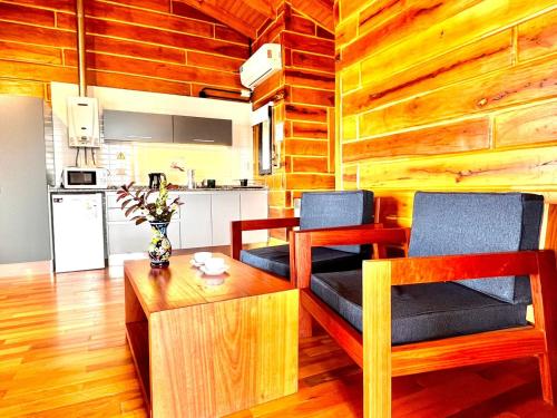 a living room with two chairs and a table at Alma Serrana - Suites de montaña! in La Cumbrecita