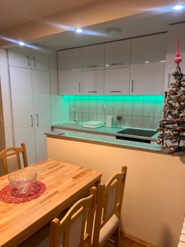 een keuken met een houten tafel en een kerstboom bij Apartman Lana in Pale